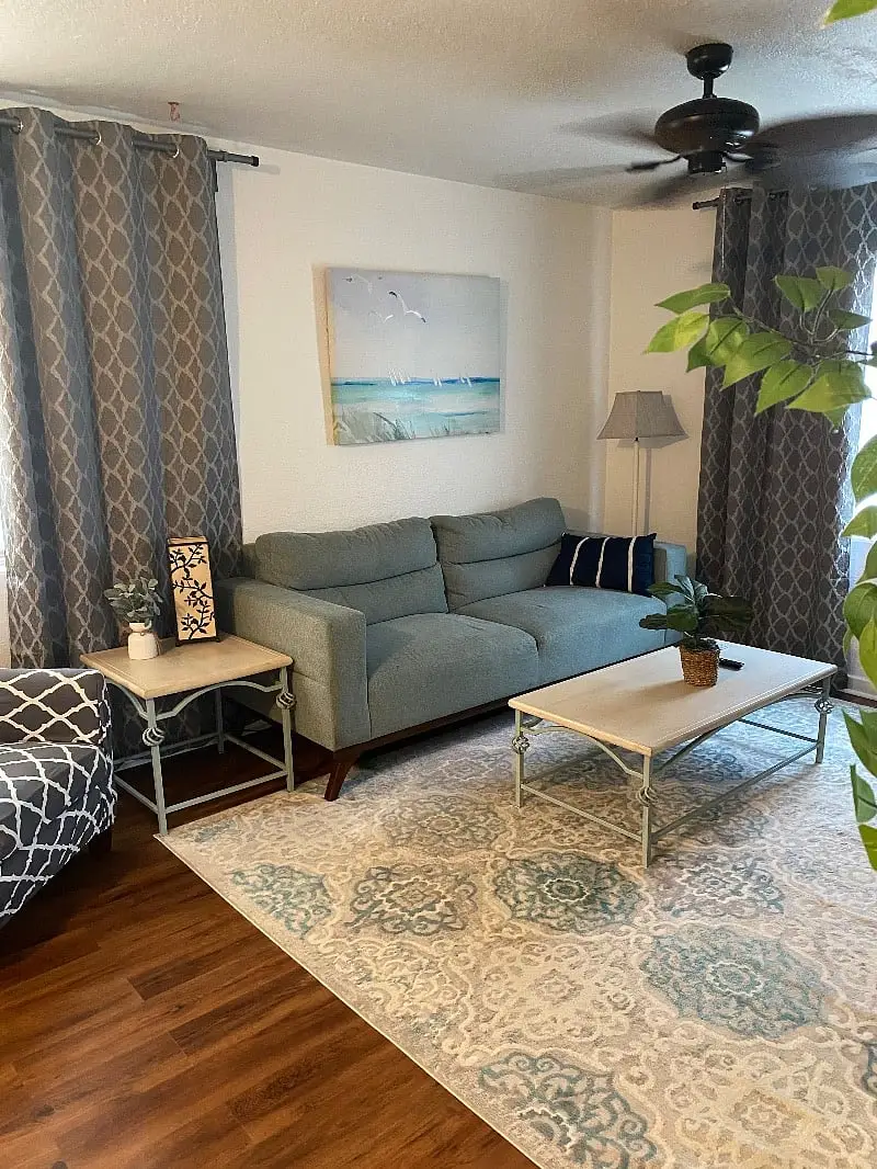 Living room seen from the entry, with a low coffee table and framed coastal prints