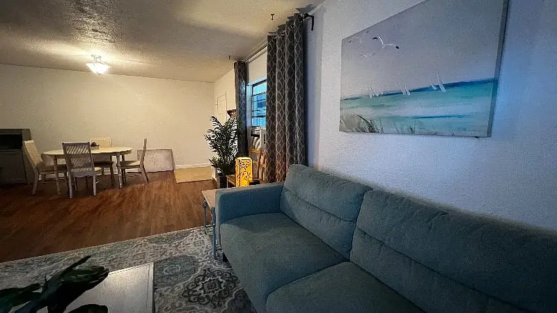 Dining table set beneath the window at the far end of the living room