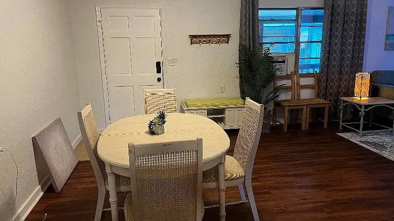 Round dining table and woven chairs beside a bright window