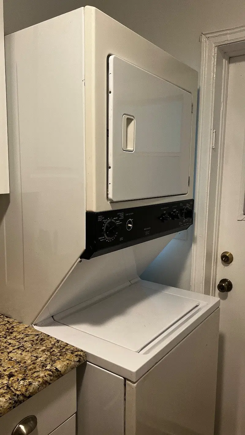 Stacked washer and dryer in a utility closet inside the unit