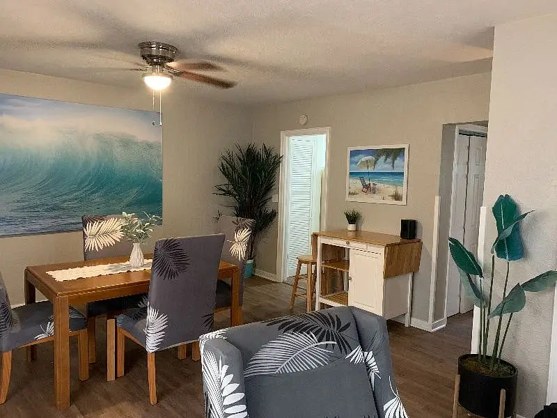 Open dining table and living area under a ceiling fan