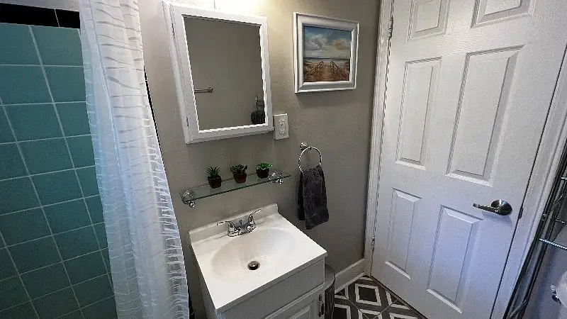 Bathroom vanity with a mirror and a framed print above the sink