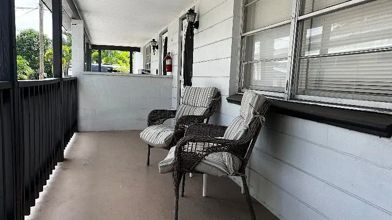 Screened porch with woven chairs looking onto the garden