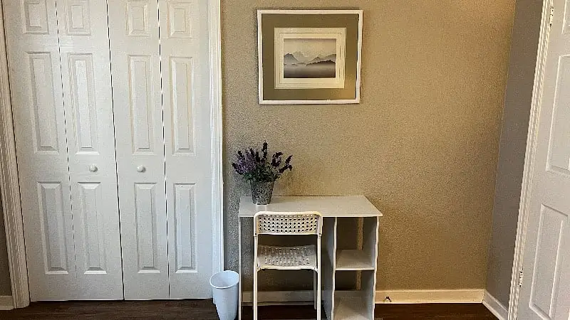 Small desk and chair beside the closet doors