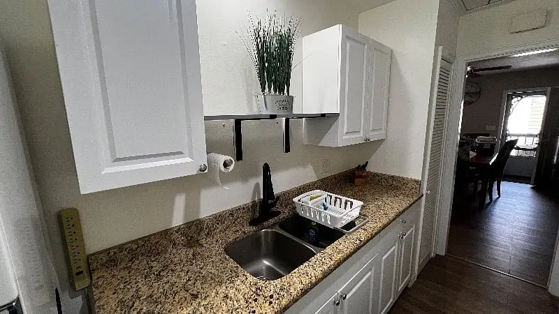 Kitchen counter, sink and cabinets seen from the dining end