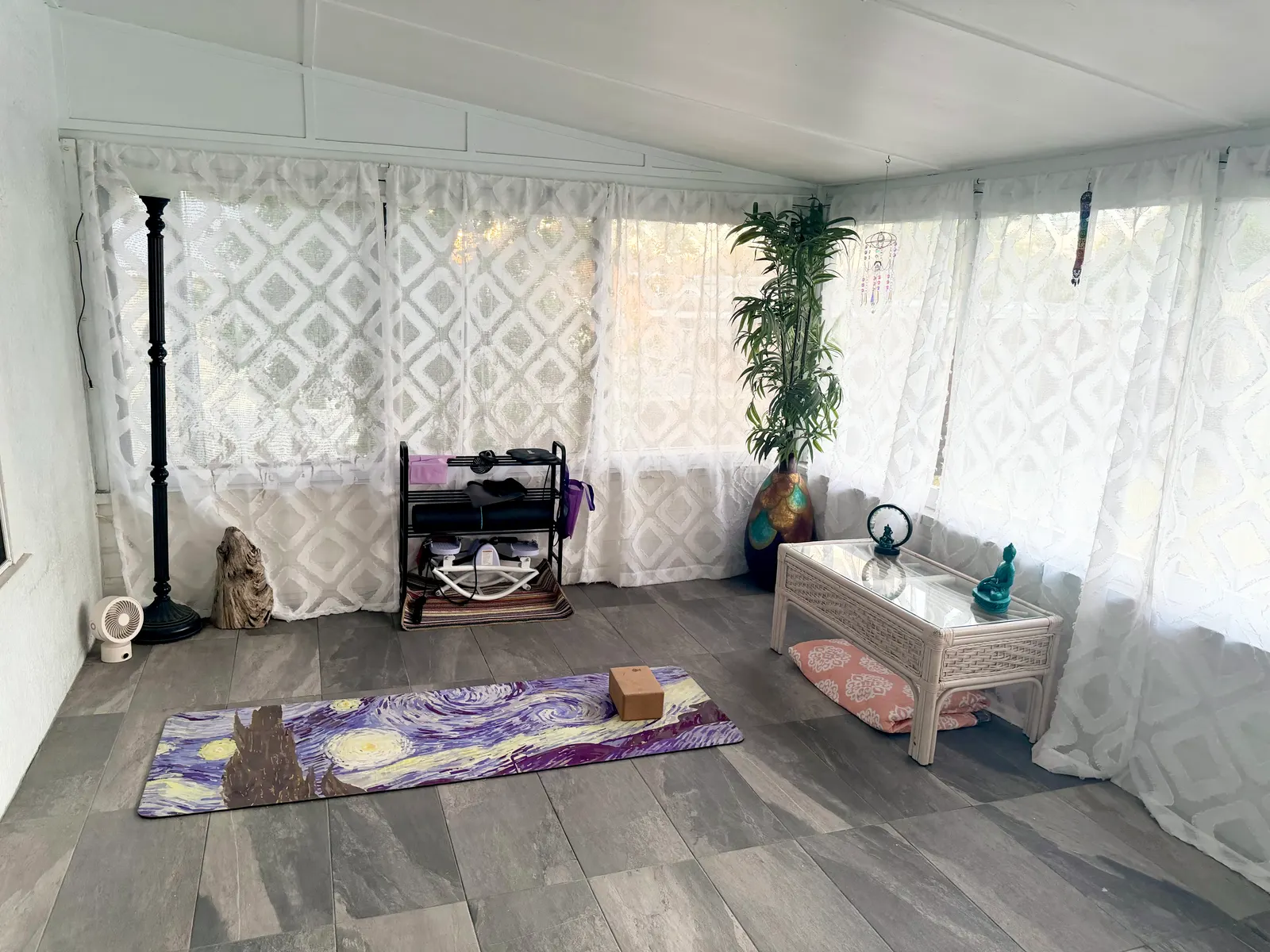 Enclosed porch on the unit's own floor, with a tile floor, lace-curtained screened windows on two sides and a low table