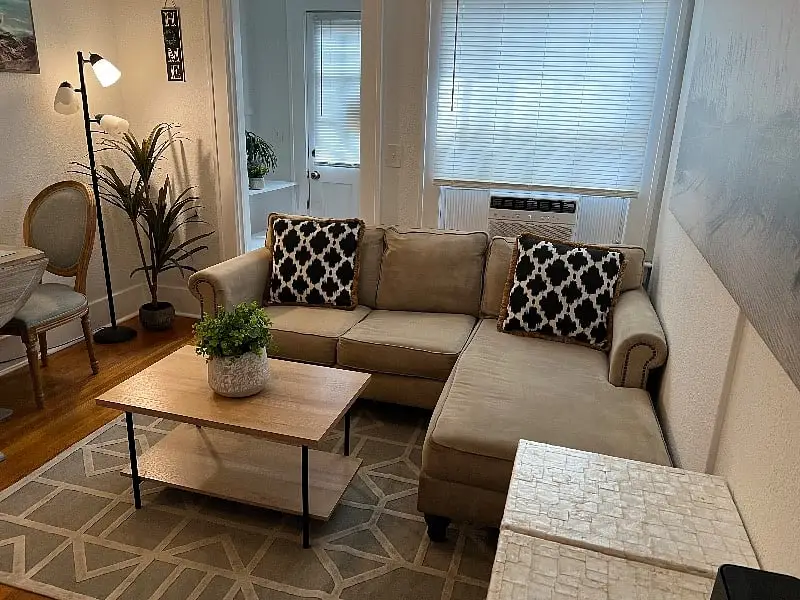 Living room sectional beneath a ceiling fan, with coastal prints on the wall