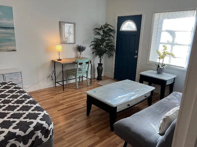 Entry with the front door, a console table and an upholstered ottoman