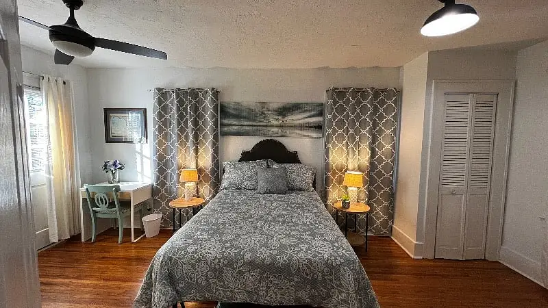 Bedroom with a dark carved headboard and a lamp on each nightstand