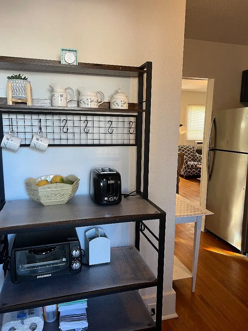 Kitchen shelving hung with mugs, next to the refrigerator