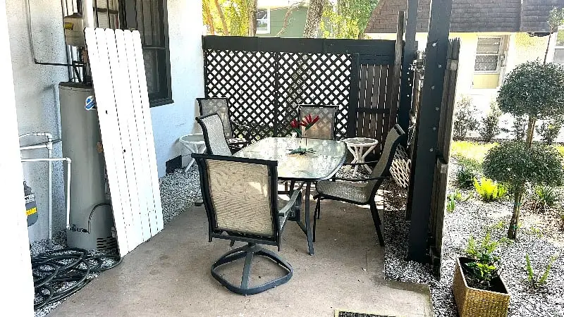 Private patio with a table and chairs behind a lattice screen
